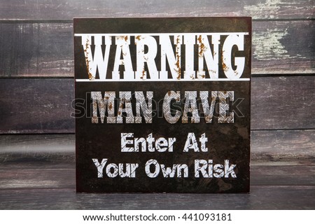 A man cave novelty sign against a wood background