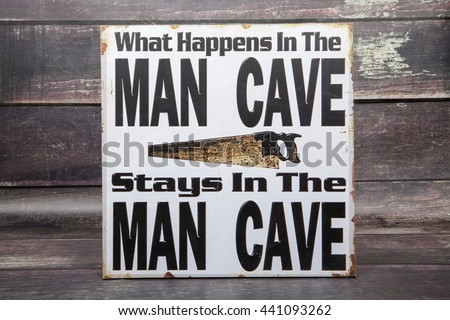 A novelty sign for the man cave against a wood background
