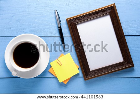 empty photo frames on wooden table with cup of coffee and post i