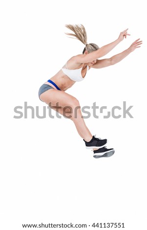 Female athlete jumping on white background