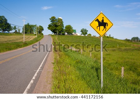 Horse crossing sign on rural road.