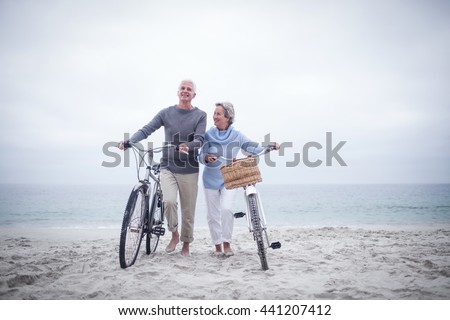 Senior couple having ride with their bike on the beach Royalty-Free Stock Photo #441207412