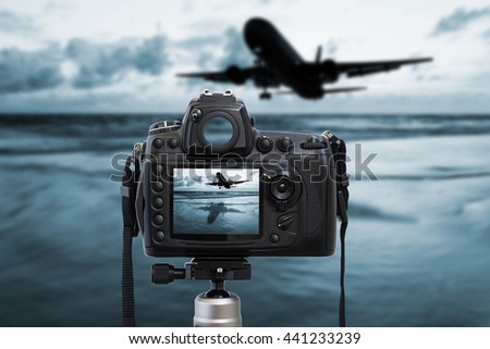 Camera photography top on blurred sea sunset and airplane background