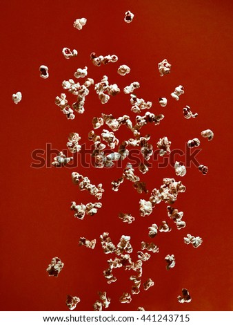 popcorn bursting in the air over colour background