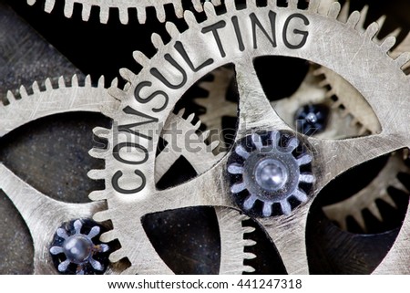 Macro photo of tooth wheel mechanism with CONSULTING concept letters