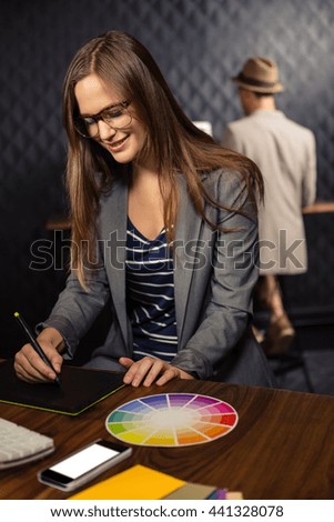 Creative businesswoman using graphic tablet in office