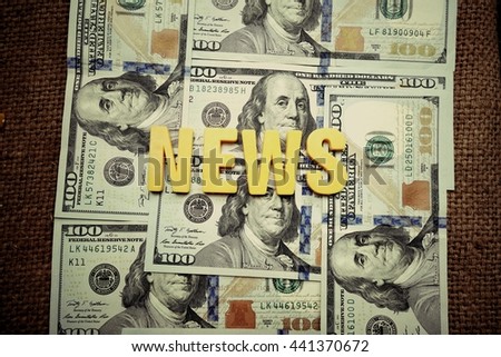 News concept. Yellow letters on a background of US dollars