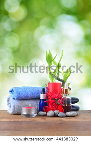 Beautiful composition of spa treatment with red candle over green bokeh background. SPA concept