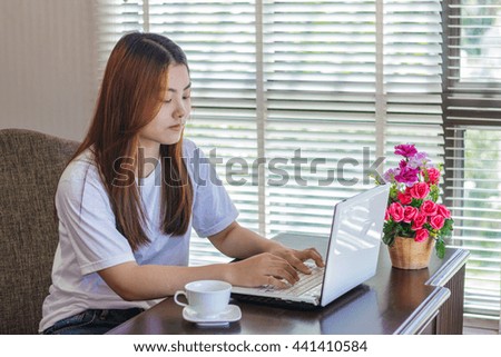 Asian woman working and smiling in office