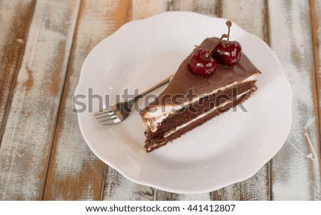 dark Chocolate cake slice on white plate mint cherry, white background