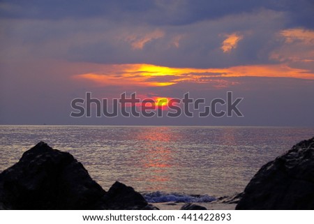 Sunrise over sea silhouette stone on beach on foreground:select focus with shallow depth of field:ideal use for background.