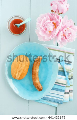 Bratwurst with bread roll and ketchup on a plate