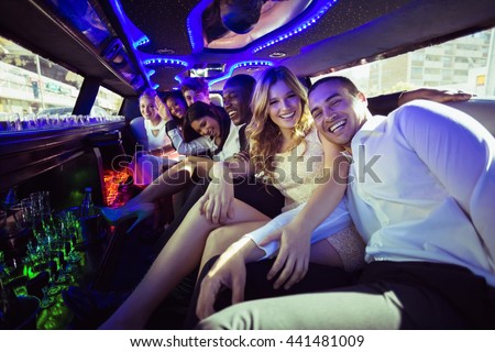 Happy friends chatting in limousine on a night out Royalty-Free Stock Photo #441481009