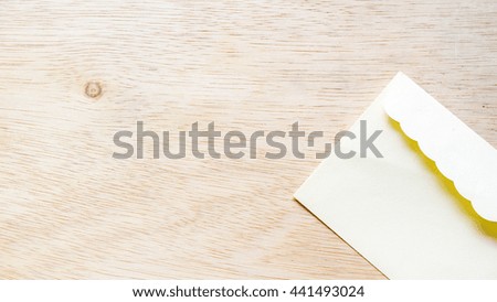 Blank envelope wrapper for greetings card on wooden surface. Isolated on empty background. Slightly de-focused and close-up shot. Copy space.