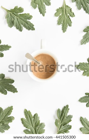 Cup of coffee with  leaves on white background. Overhead view. Flat lay, top view.