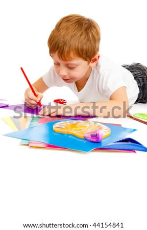 Preschool boy drawling with a red pencil