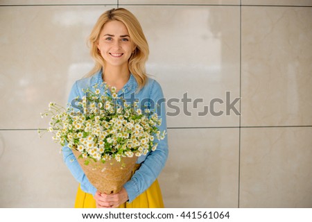girl holding bouquet of camomiles