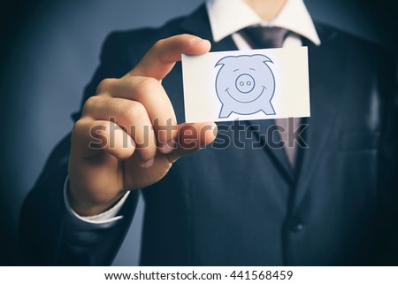 Elegant man in suit holding business card with picture of piggy bank
