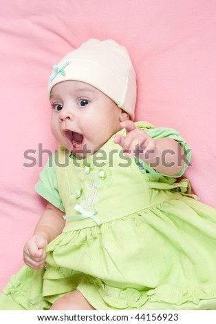 Little 3 months baby-girl dressed in green suit portrait