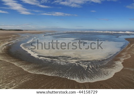 Clouds under the sandy seashore and a little bay