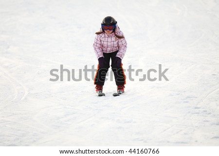 Little girl learning downhill alpine skiing