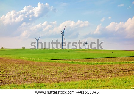 Windmills, eco power, wind turbines on farmland Royalty-Free Stock Photo #441613945
