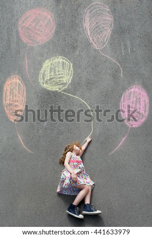 Dreamy little girl l flying with painted balloons. Happy childhood concept.