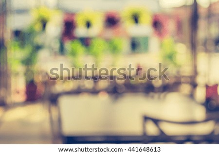 image of Abstract blurred outdoor table and chair in garden on day time for background usage . (vintage tone)