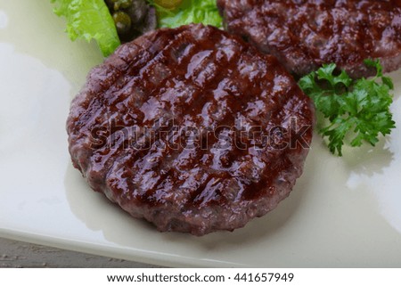 Grilled burger cutlet with salad leaves