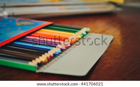 Colored pencils in Box on a wooden board in Paper box.