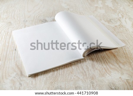 Blank magazine pages. Photo of blank opened magazine with soft shadows on wooden table background. Mock-up for graphic designers portfolios.