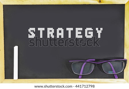 STRATEGY word in blackboard with chalk and glasses