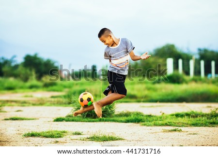An action picture of a kid is playing soccer football for exercise. A film picture style with grain.