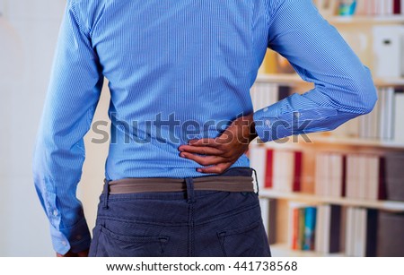 Man touching his back with one of his hand, back pain