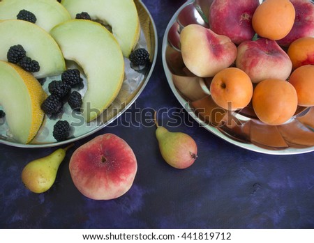 Melon, blackberries, apples, peaches and pears on a dark background