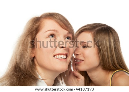 Two pretty blond girls whispering about their secrets; isolated on white background
