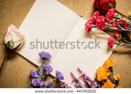 Book and flowers on wooden table