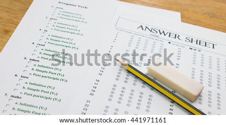 english exerciser and answer sheet on brown wooden table represent testing english grammar Royalty-Free Stock Photo #441971161