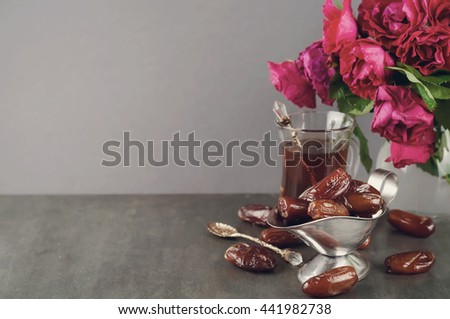 Traditional arabic tea set and dried dates. Isolated white background. Toned photo