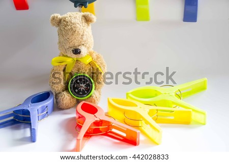 Bear is holding compass with plastic clips around