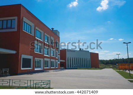 Modern school building. Empty school yard. Sunny day, blue sky. Royalty-Free Stock Photo #442071409