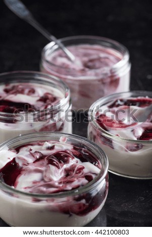 Yogurts with fruits assortment in glass bowls on dark marble background. Natural and fruit healthy, diet, gourmet dessert for granola breakfast. Sweet yoghurts closeup.