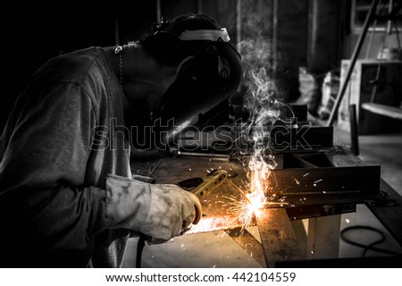 Man welding work,Welding steel sparks Royalty-Free Stock Photo #442104559