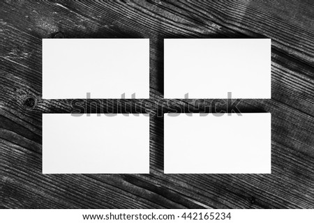 Photo of blank white business cards on wood table background.. Mock-up for branding identity for designers. Isolated with clipping path. Top view.