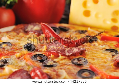 Close up of  pizza with tomatoes, cheese, black olives and  pepper