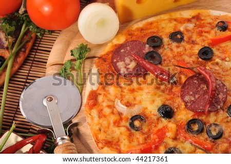 Close up of  pizza with tomatoes, cheese, black olives and  peppers.