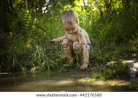child plays in the mud Royalty-Free Stock Photo #442176580