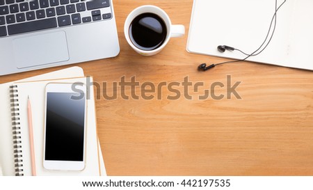 Portable computer laptop, smartphone, pencil, paper notebook, cup of coffee on wood table, with copyspace for text