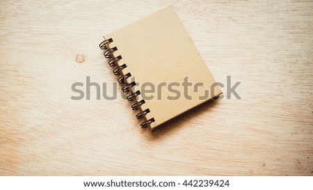 Retro styled or retro color blank cover notepad or memo pad diary book on wooden surface. Isolated on an empty background. Slightly de-focused and close-up shot. Copy space.