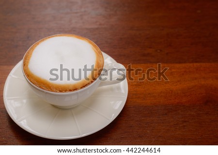 Hot cappuccino with beautiful latte art on wooden table. vintage retro filte